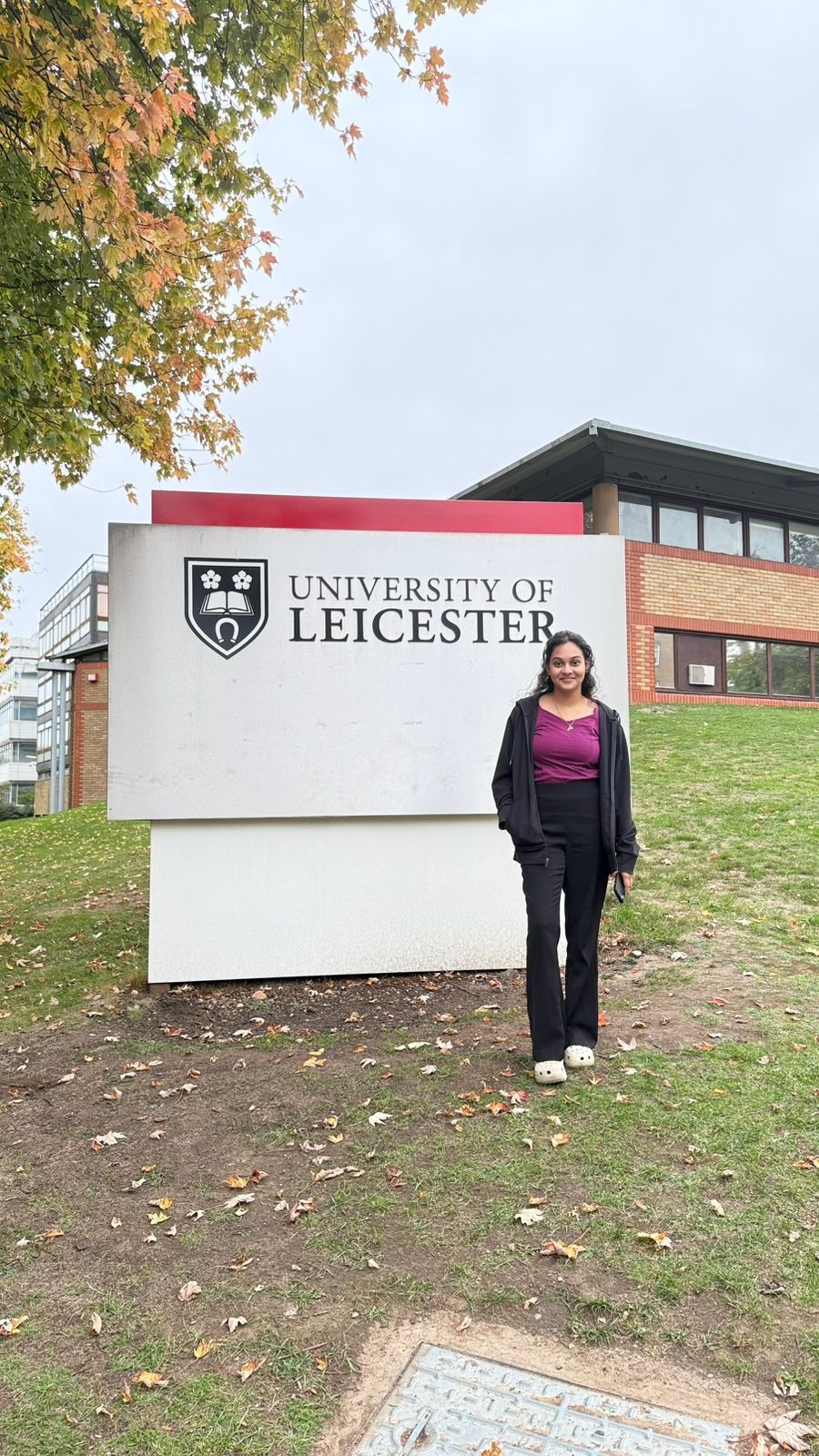 Bindushree standing beside the University of Leicester sign